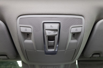 Interior view with steering roof panel dashboard of light control of luxury very expensive new white car stands in the washing box