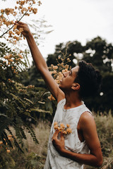 teenager in the garden picking yellow flowers