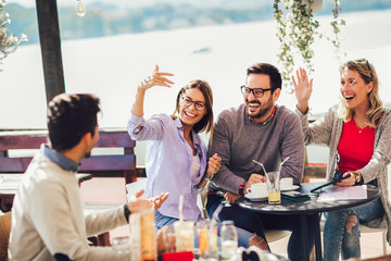 Cheerful group of friends having fun in cafe, make selfie photo.