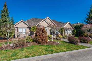 Beautiful exterior of newly built luxury home. Yard with green grass and walkway lead to front entrance.