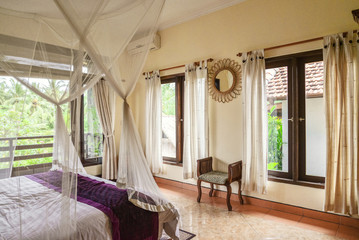Cozy canopy bed in bedroom with balcony