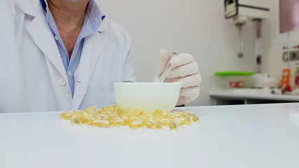 Pharmacist preparing gelatinous oil capsules in the pharmacy laboratory