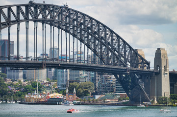 Naklejka premium SYDNEY - OCTOBER 2015: Panoramic view of Sydney Harbor on a sunny day. The city attracts 20 million people annually