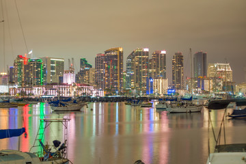 Fototapeta na wymiar SAN DIEGO, CA - JULY 31, 2017: Night reflections of Downtown San Diego from the city port. The city attracts 10 million tourists annually