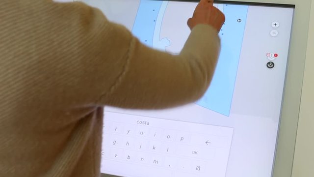 The woman uses an interactive panel as a shopping center guide. Paves the way to the desired store