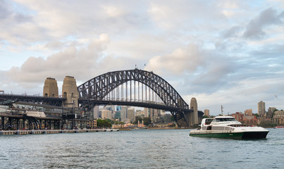 Fototapeta na wymiar SYDNEY - NOVEMBER 6, 2015: Beautiful view of Sydney Harbor on a cloudy day. Sydney attracts 20 million tourists every year
