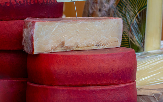 big circles of french cheese in red paraffin
