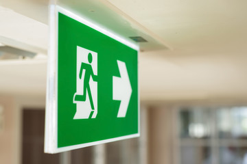 Selective green fire exit sign on ceiling.Fire fighting equipment concept