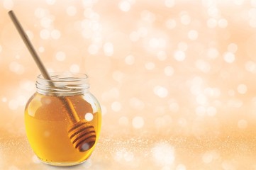 Fresh sweet honey with wooden honey dipper in glass jar isolated on white background