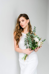 beautiful girl holding bouquet of flowers on grey