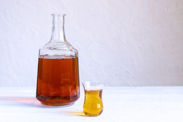 Vintage carafe with wine and glass on white rustic background.
