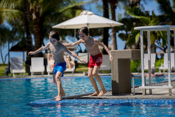 Naklejka premium Happy children, brothers, having fun in the pool