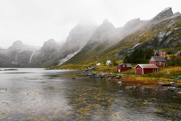 Panoramic view of a remote old fishing village at the coast in Vinstad with mountains in the background on Lofoten Islands in Norway.