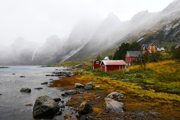Panoramic view of a remote old fishing village at the coast in Vinstad with mountains in the background on Lofoten Islands in Norway.