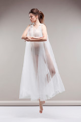 Fototapeta premium Beautiful ballet-dancer, modern style dancer posing on studio background