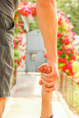 Naklejka premium beautiful hands of a child and a parent in a park in nature