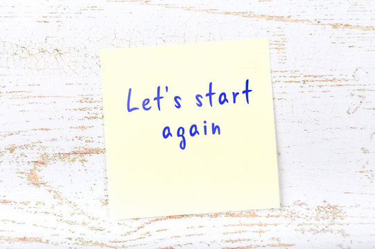 Yellow sticky note with handwritten text lets start again