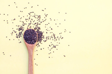 wooden spoon with chia seeds isolated on yellow background, top view, copy space, flat layout,...