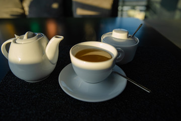 white cup with kettle on cafe table
