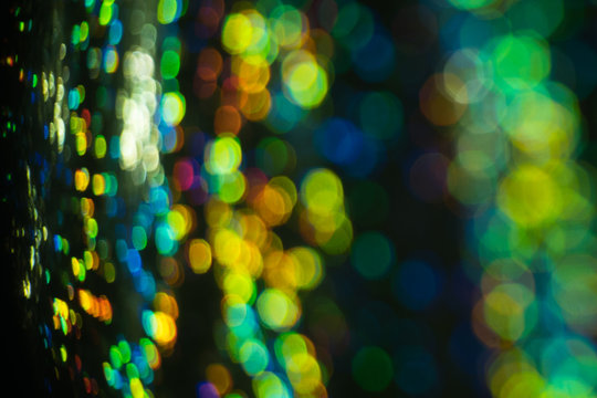 Blurred city night light reflection. Glowing multicolor spots. Bokeh lens flare effect.