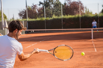 Professional tennis player man playing on court in afternoon.