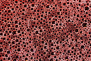 Soap suds bubble pattern. Red water foam on black frying pan texture.