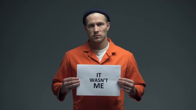 European imprisoned man holding It was not me sign, wrongly convicted person