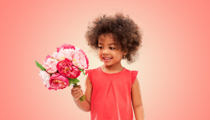childhood and people concept - happy little african american girl with flowers over living coral background