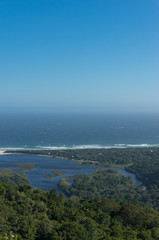 Fototapeta na wymiar Vast ocean and river mouth lagoon surrounded by forest. Aerial landscape