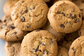 food, junk-food and eating concept - close up of oatmeal cookies with chocolate chips on plate