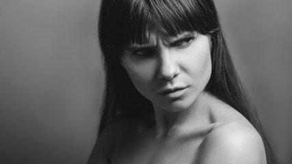 Offended beautiful girl. Angry facial expression. Black and white closeup portrait of emotional...