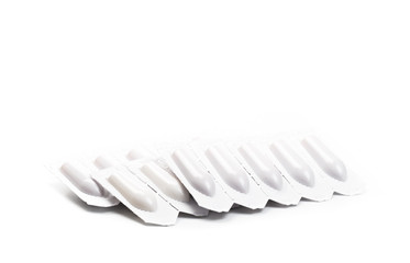 plastic packs of suppositories on white  background