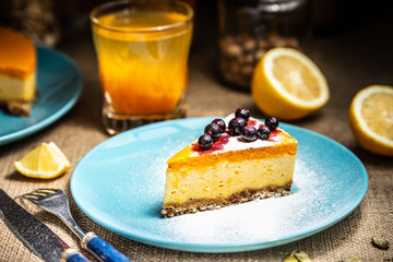 Cheesecake slice on a blue plate. Sugar snow.