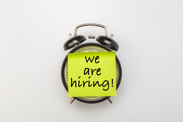 paper stick on clock for notice something with white background . hiring vacant