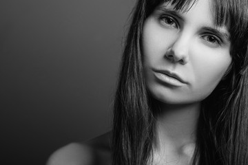 Disenchanted beautiful girl. Distrustful facial expression. Black and white closeup portrait of emotional lady. Copy space.