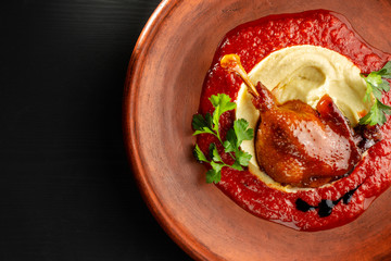 Roasted duck leg with mashed potatoes and tomato sauce.