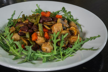 Vegetarian vegetable salad with mushrooms, arugula, carrots, beans and pepper