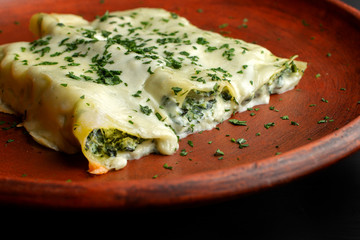 Rolls of pancakes with cottage cheese, herbs and cheese.