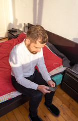 young turkish man checking smartphone in his bedroom in waiter clothes