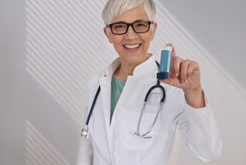 Female Doctor giving an asthma inhaler to the patient close up