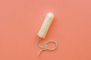 Menstrual period concept. Woman hygiene protection. Cotton tampons on coral background. Top view, flat lay