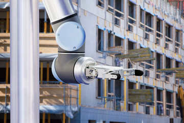 Robotic arm on a background of a scaffolding. Digital transformation and internet of things in construction industry.