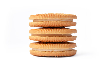 Three stacked cookies filled with white cream isolated on white background