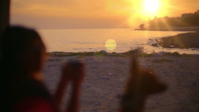 Perfect adventure and wanderlust broll inspirational and dreamy shot of sunset over beach, blurred young woman and pet dog in foreground enjoying vanlife and amp vibes in outdoors