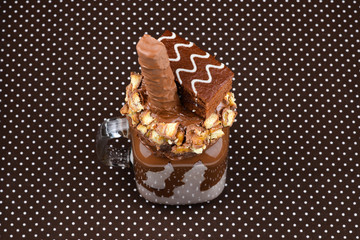 Chocolate extreme milkshake with brownie cake, chocolate paste and sweets. Crazy freakshake food trend. Copy space