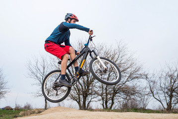 Obraz na płótnie Canvas Man on a mountain bike performing a dirt jump.