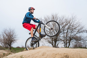 Man on a mountain bike performs a dirty jump. Active lifestyle.