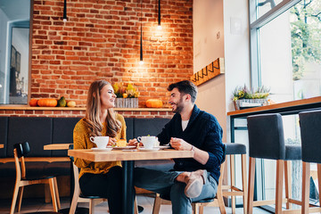 Picture of young couple dating at cafe. Young woman and man at coffee shop. - obrazy, fototapety, plakaty