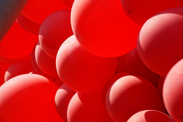 Red helium air balloon with calm blue cloudy sky on background. Peace and holiday concept. Bottom view. Copyspace for minimalistic design.