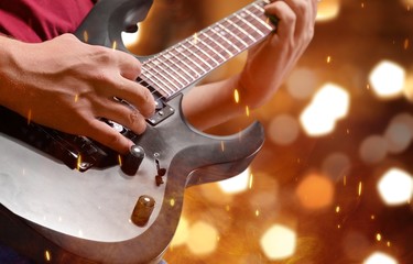 Fototapeta premium Male Guitarist playing music on background